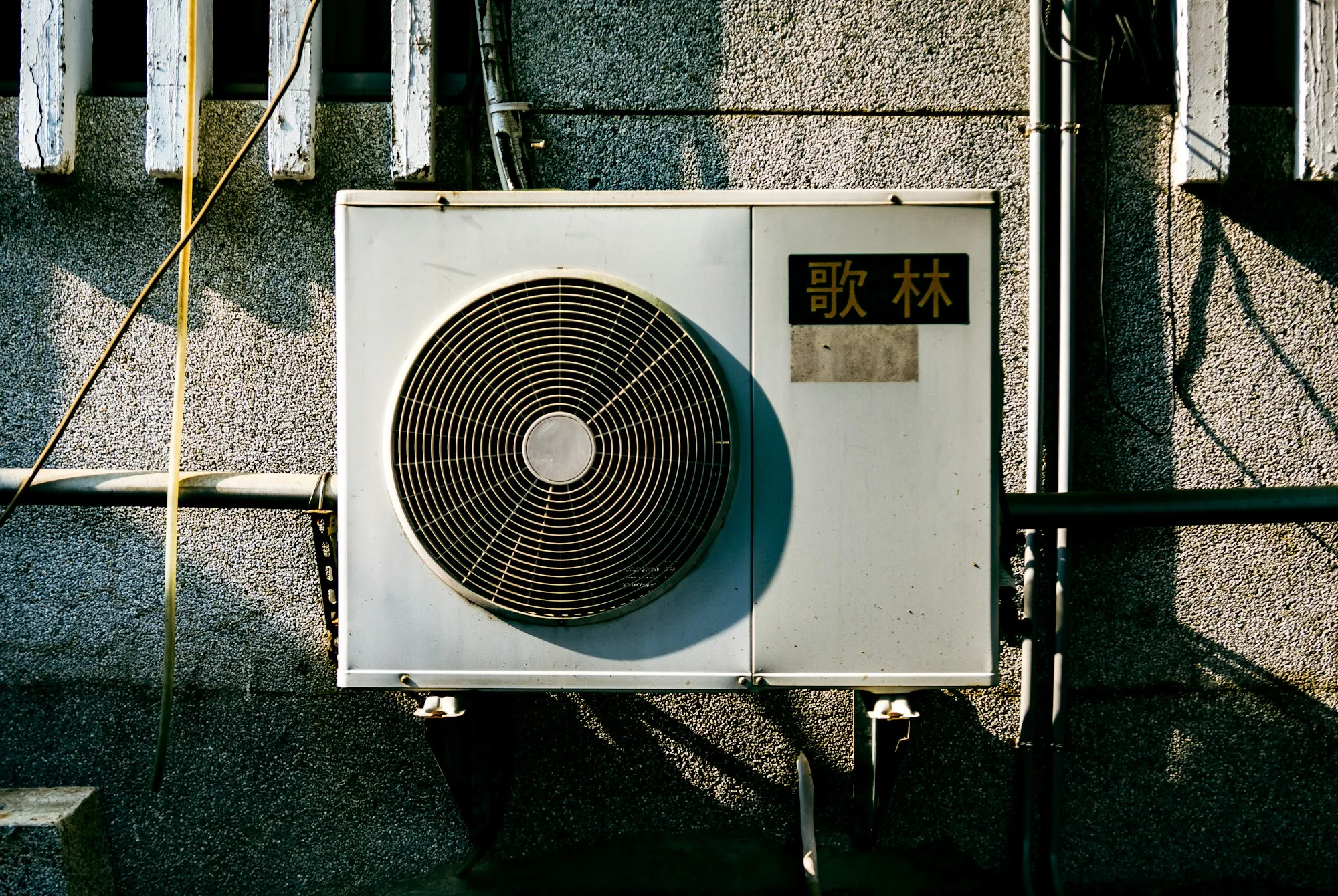 A wall-mounted air conditioning unit on the outside of a building