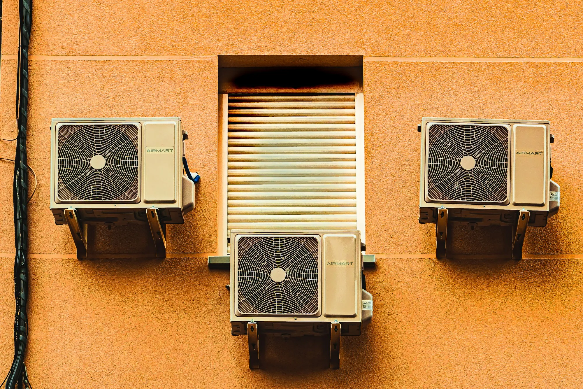 A box fan sitting in an open window of a building